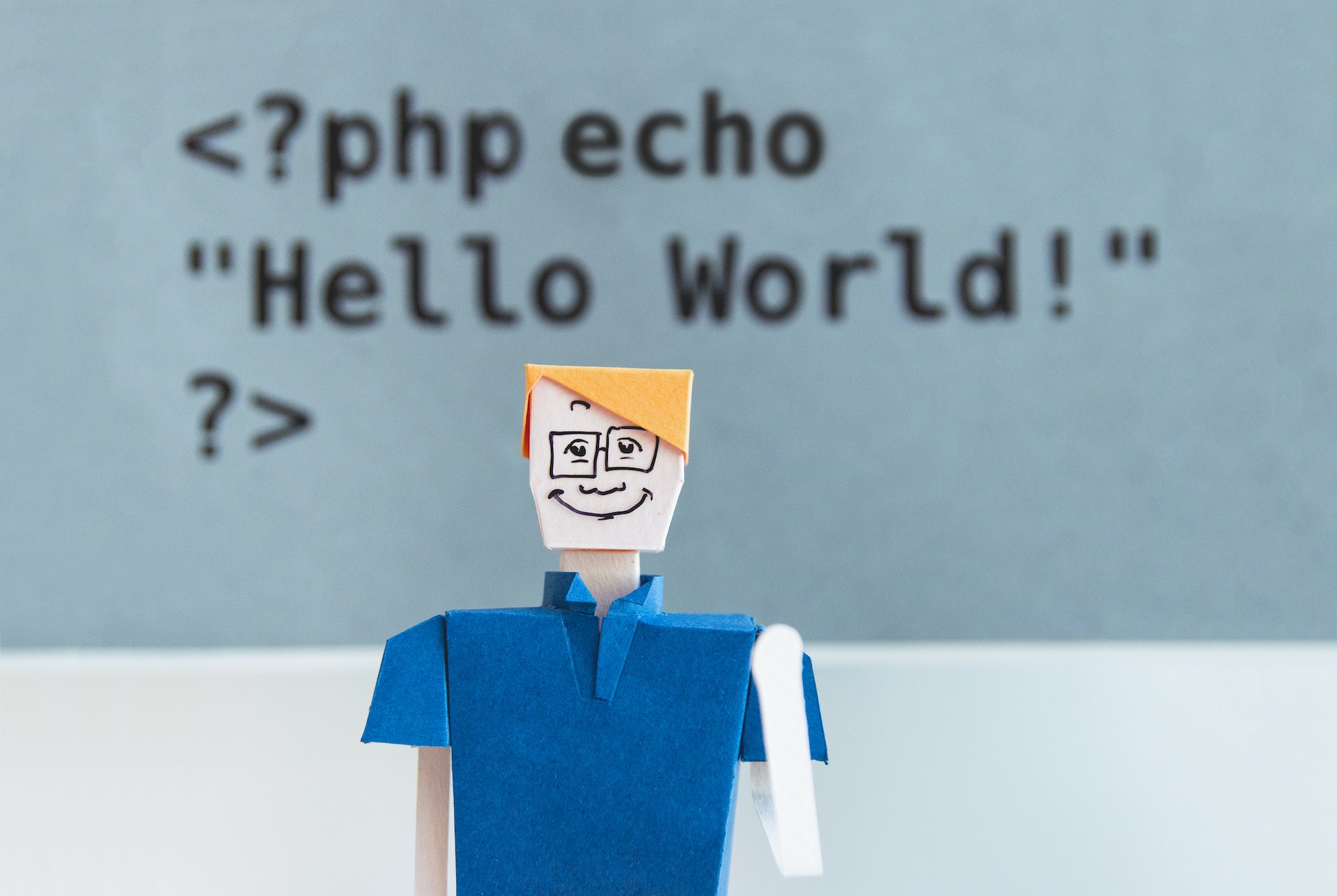 Figure standing in front of PHP Hello World code