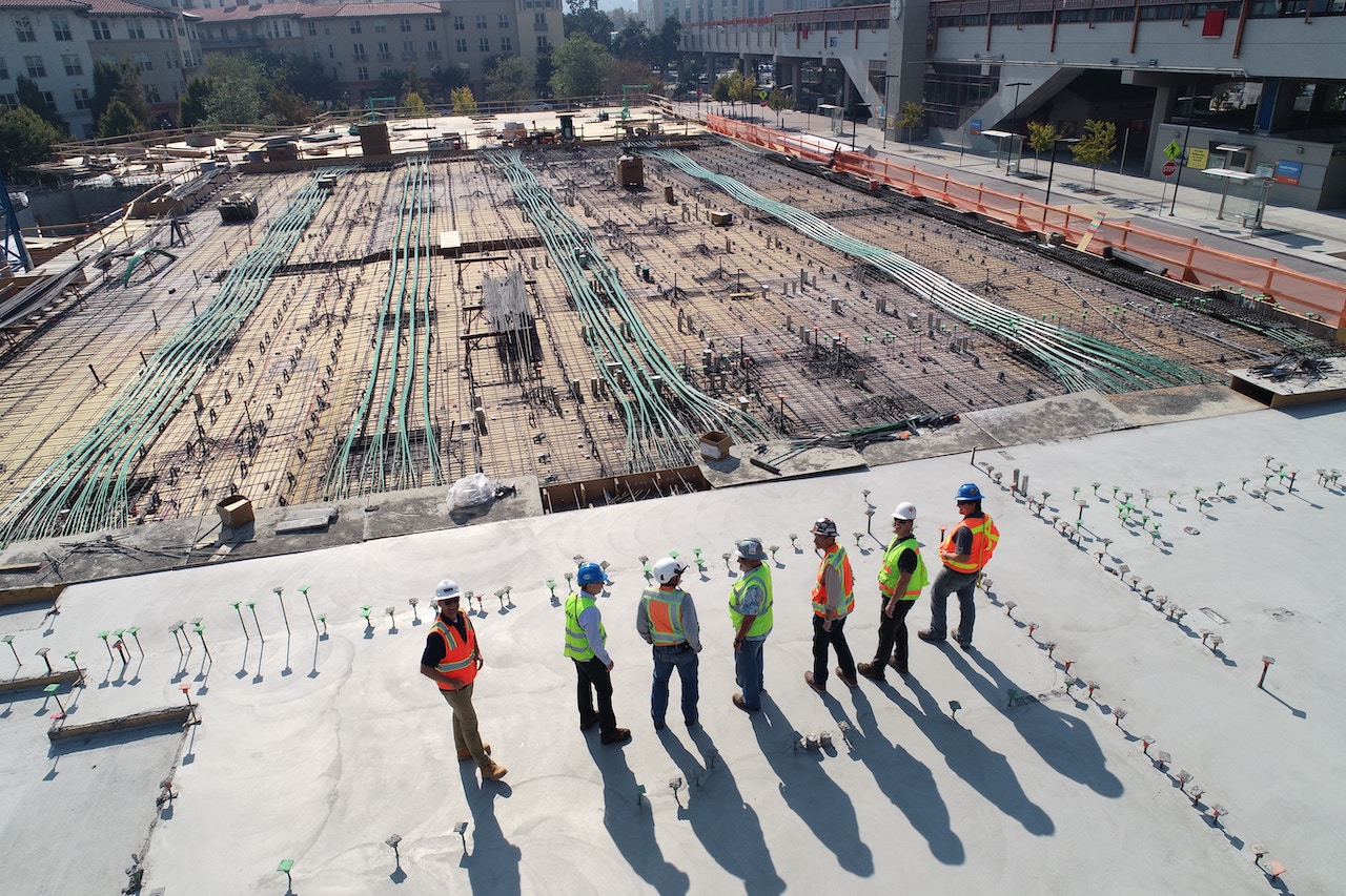 Construction workers stand and look at the foundations of their on-going construction project