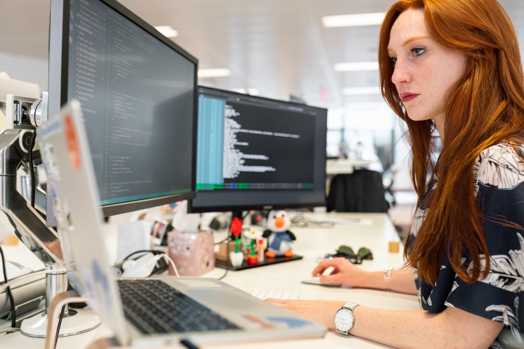 An engineer, at a desk, working on computer code